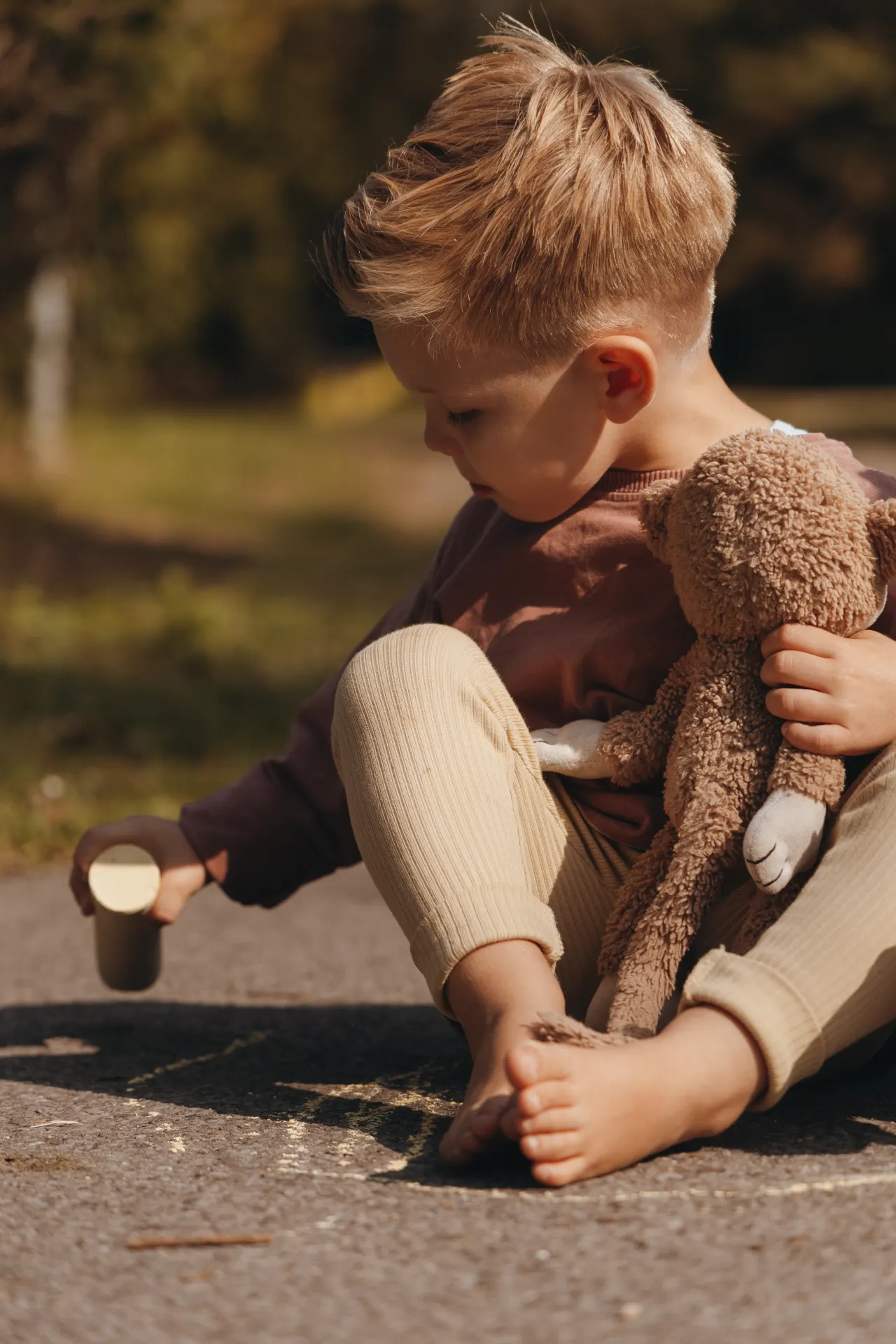 Kind mit Teddybär bei einem entspannten Fotoshooting