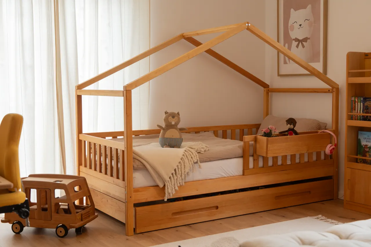 Kinderzimmer mit Hausbett, Schreibtisch und Spielzeugbus aus Holz