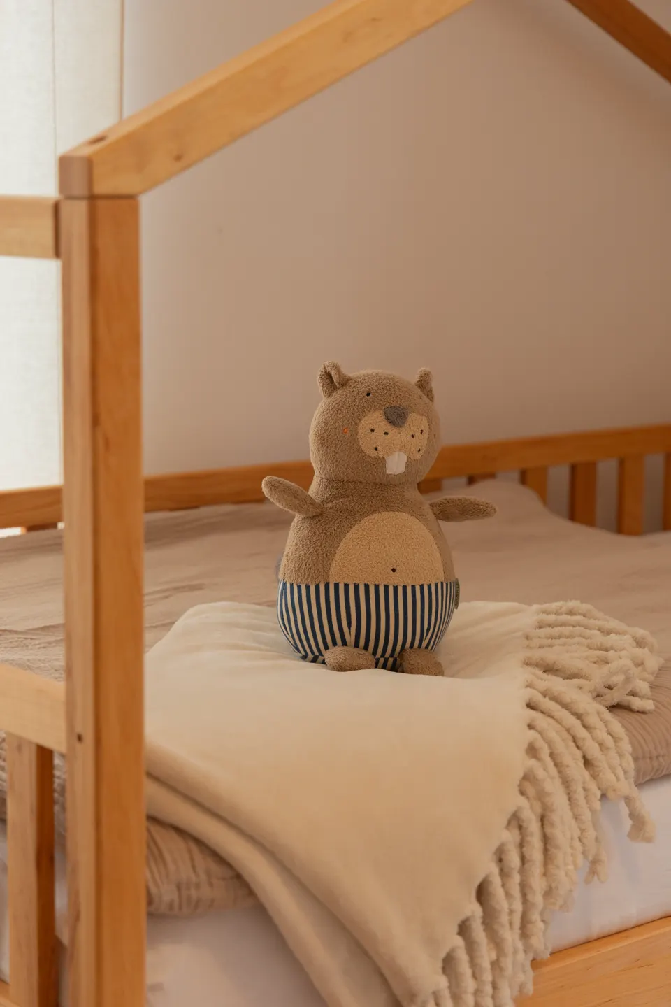 Detail: Kuscheltier auf einer Decke mit Fransen